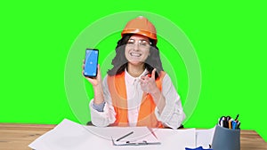 Female architect showing phone screen and thumbs up on the chroma key