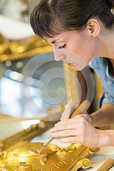 Female artisan working with gold leaf