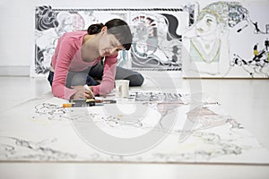 Female Artist Drawing On Large Paper