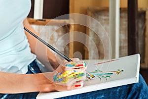 Female artist hand holding paintbrush