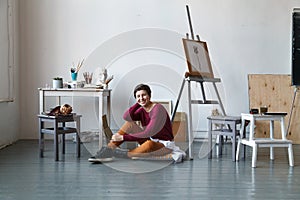 Female artist in her spacious white studio working with watercolor painting