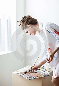 Female artist mix with brush color oil painting on palette