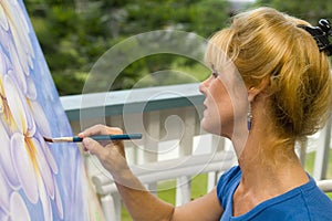 A female artist painting on canvas