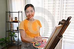 Female artist painting picture with watercolor in bright daylight studio. Art, creative hobby and leisure activity