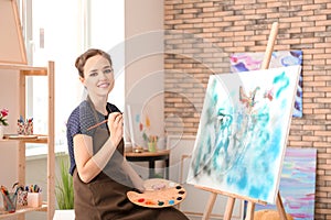 Female artist painting picture in workshop