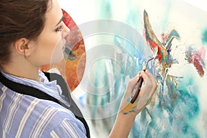 Female artist painting picture in workshop