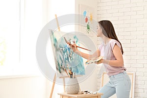 Female artist painting picture in workshop