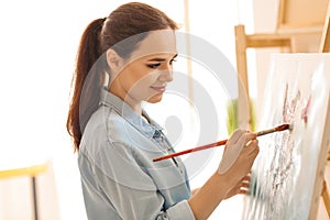 Female artist painting picture in workshop