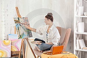 Female artist painting picture in workshop