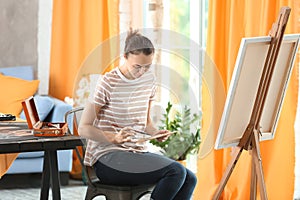 Female artist painting picture in workshop