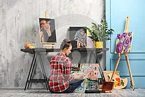 Female artist painting picture in workshop