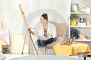 Female artist painting picture in workshop