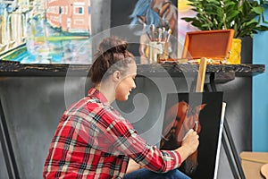 Female artist painting picture in workshop