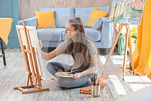 Female artist painting picture in workshop