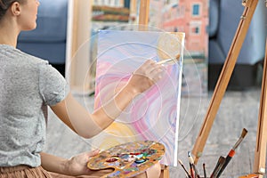 Female artist painting picture in workshop