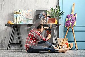 Female artist painting picture in workshop