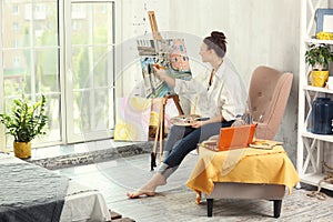 Female artist painting picture in workshop