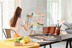 Female artist painting picture in workshop