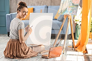 Female artist painting picture in workshop