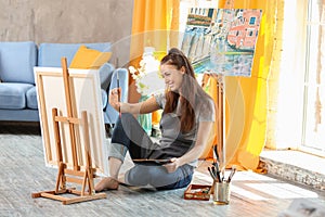 Female artist painting picture in workshop