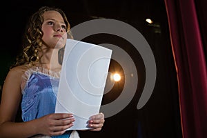 Female artist reading her scripts on stage