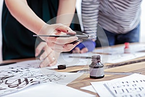 Female artist wearing hand having dirty hands after writing in ink