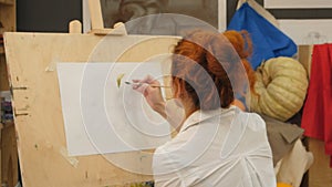 Female artist working on watercolor painting in studio photo