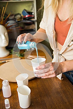 Female artist works on abstract fluid art painting with marble effect