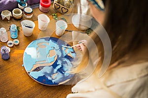 Female artist works on abstract fluid art painting with marble effect