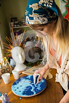 Female artist works on abstract fluid art painting with marble effect