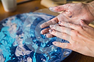 Female artist works on abstract fluid art painting with marble effect