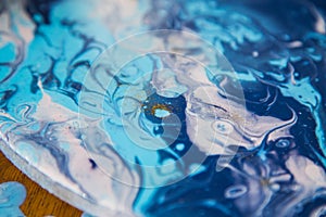 Female artist works on abstract fluid art painting with marble effect