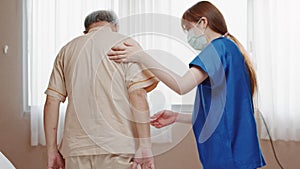 Female Asian nurse support senior male patient stand up and walk from bed in hospital. Nursing home, medical service concept