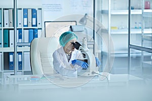 Female Asian Pharmacologist Using Microscope