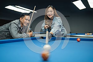 female asian player smiling while poking the ball using her stick