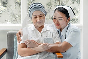 Female Asian senior patient holding health insurance card with asian nurse encourage her to have confident to sickness expense