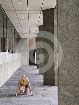 Female Athlete Crouching In Starting Position In Portico