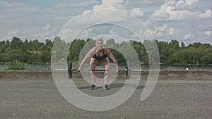 Female athlete doing crossfit deadlifts outdoors