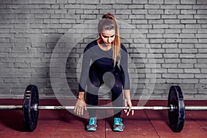 Female athlete doing deadlift at gym