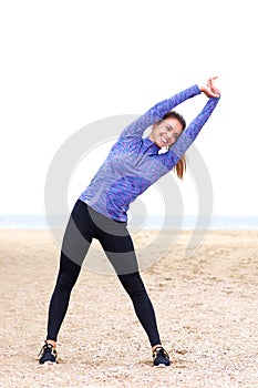 Female athlete doing yoga in sand