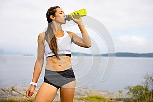 Female Athlete Drinking Water During Outdoor Workout
