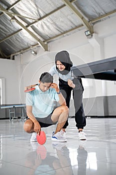 female athlete in hijab encouraging male partner disappointed