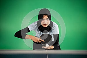 female athlete in hijab preparing to serve
