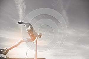 Female athlete jumping above the hurdle during the race