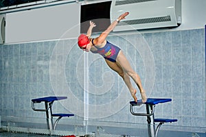 Female athlete jumps to the pool water. Middle-aged woman professionally engaged in swimming photo