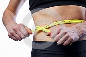 Female athlete measuring waist, checking results of active workouts