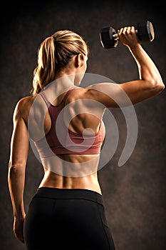 Female Athlete Performing Single Arm Dumbbell Lift Highlighting Functional Strength