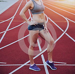 Female athlete in position ready to run.