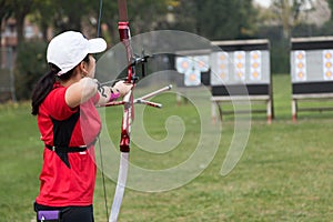 Female athlete practicing archery in stadium