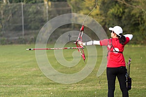 Female athlete practicing archery in stadium